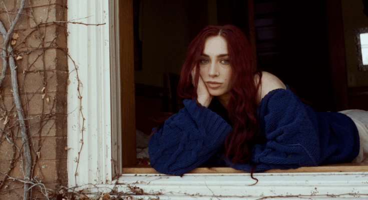 Musician Anna Graves posing on a window sill.