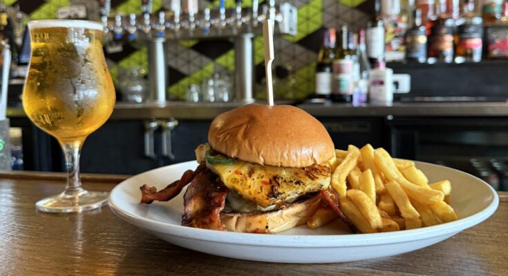 A beer and burger and fries plated at Bobcat Bonnie's in Ferndale, Mich.