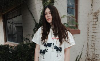 Sydney Sprague wearing a white t-shirt with cows on it.