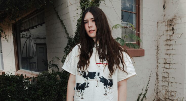 Sydney Sprague wearing a white t-shirt with cows on it.