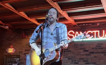 Brian Aubert playing an acoustic guitar at Sanctuary Detroit in Hamtramck, Michigan.