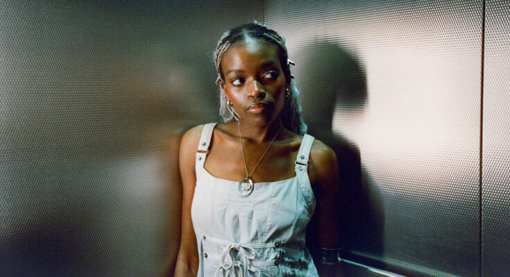 Singer Hannah Jadagu posing in an elevator.